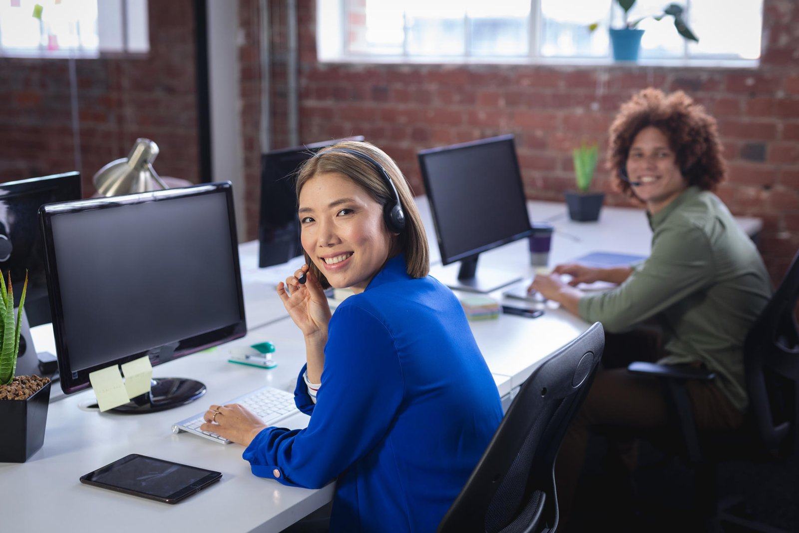 Medewerker met headset in gesprek op kantoor, symbool voor de outreach die aan een gastbijdrage of samenwerking voorafgaat